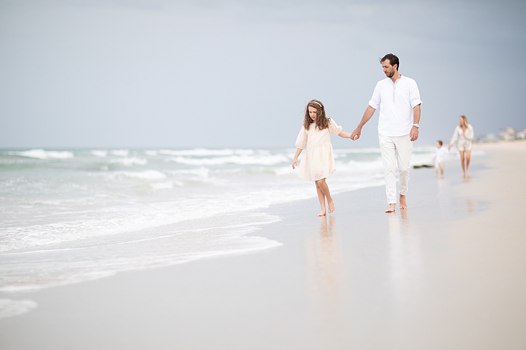 father and daughter walking on the beach during their sweet family beach session