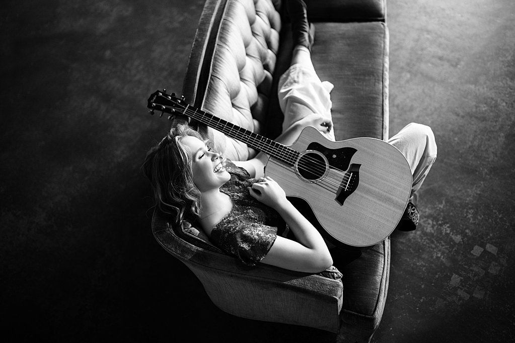 girl with guitar on couch 