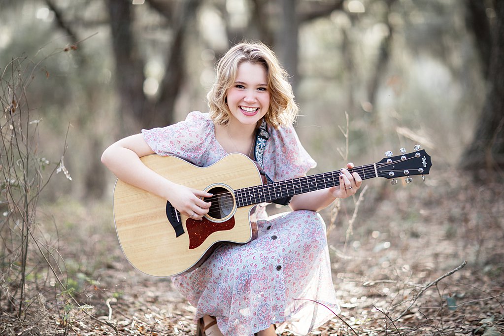 girl smiling playing guitar 