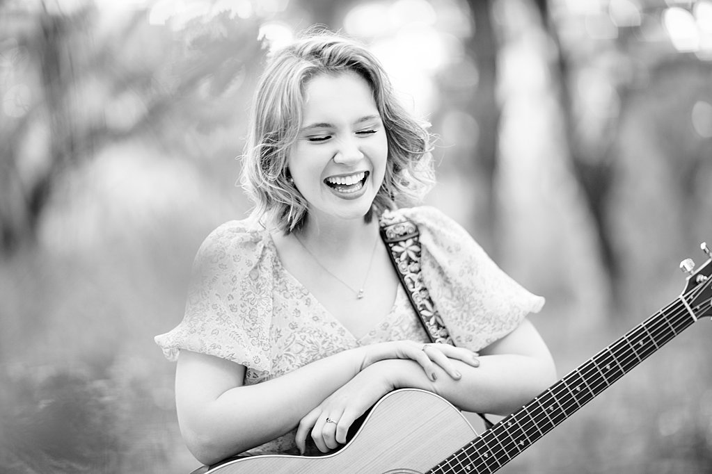 girl laughing while holding guitar during senior session