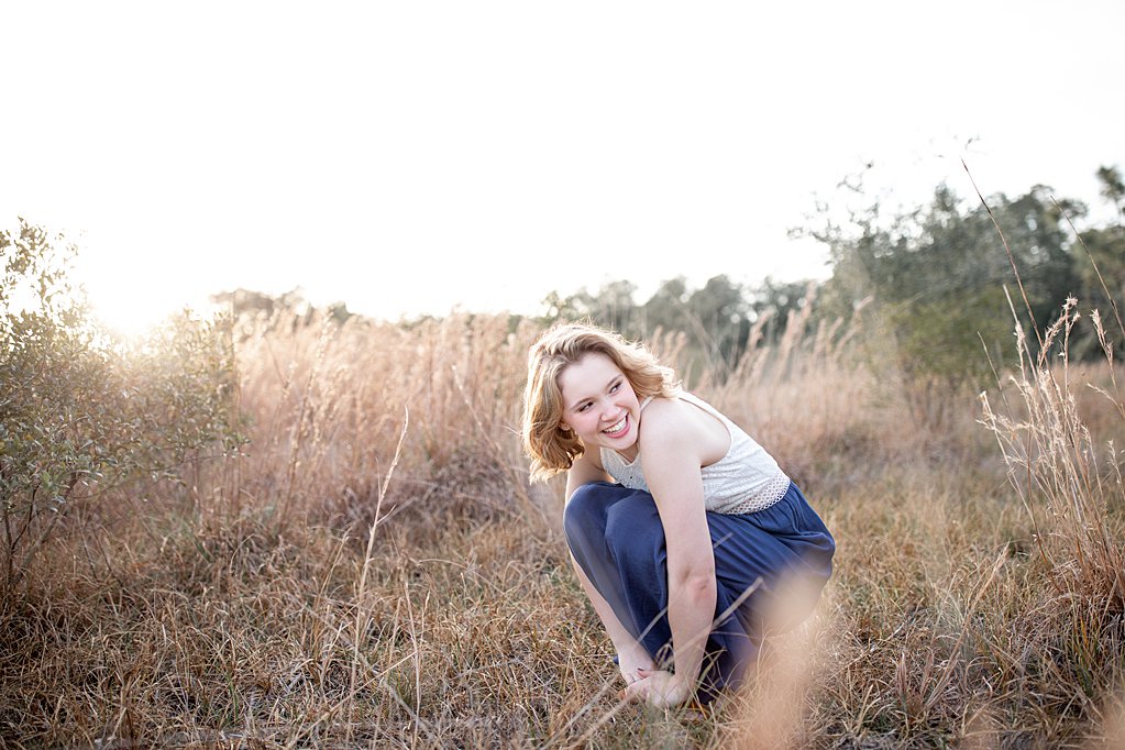 girl laughing in field during senior session