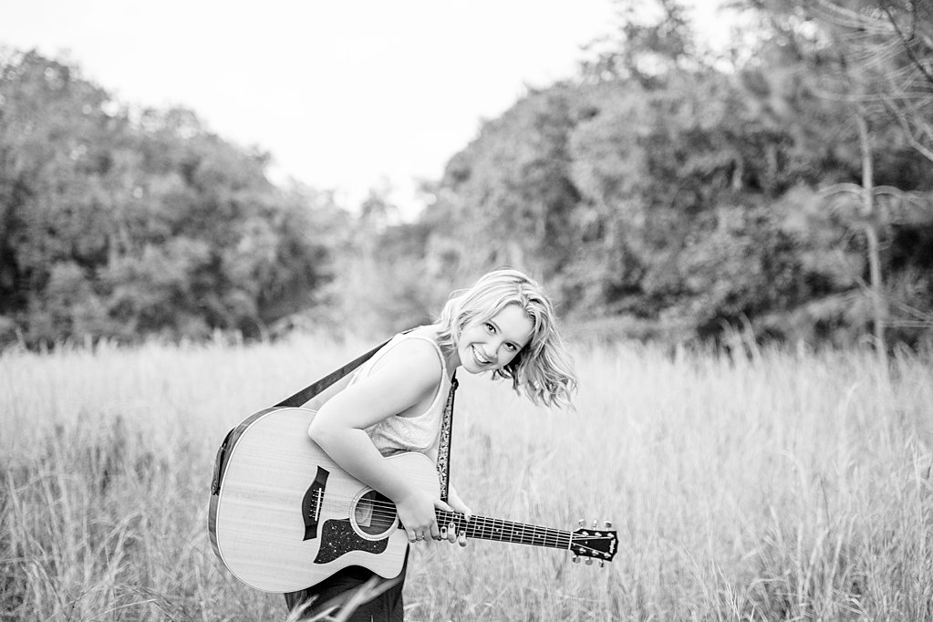 girl with guitar at senior session in field