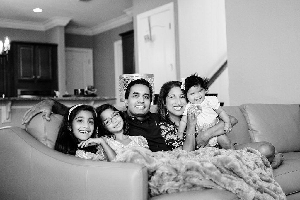 Family of five smiling at the camera on the couch