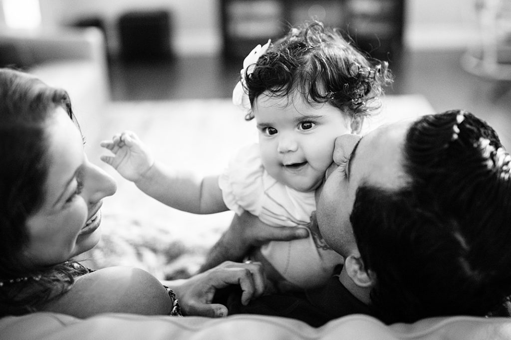 dad kisses little girl while mom smiles at family storyteller session