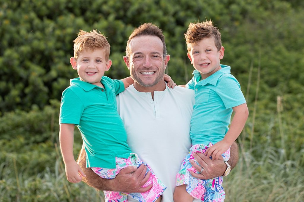 dad and sons smiling at the beach
