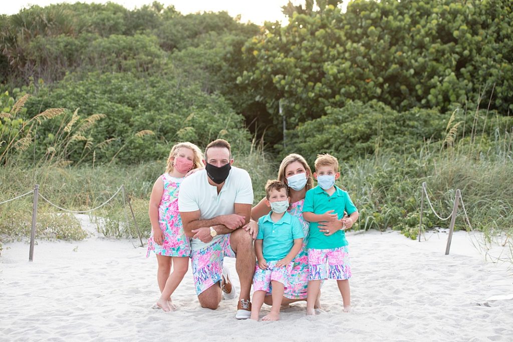 family wearing mask for a portrait at the beach