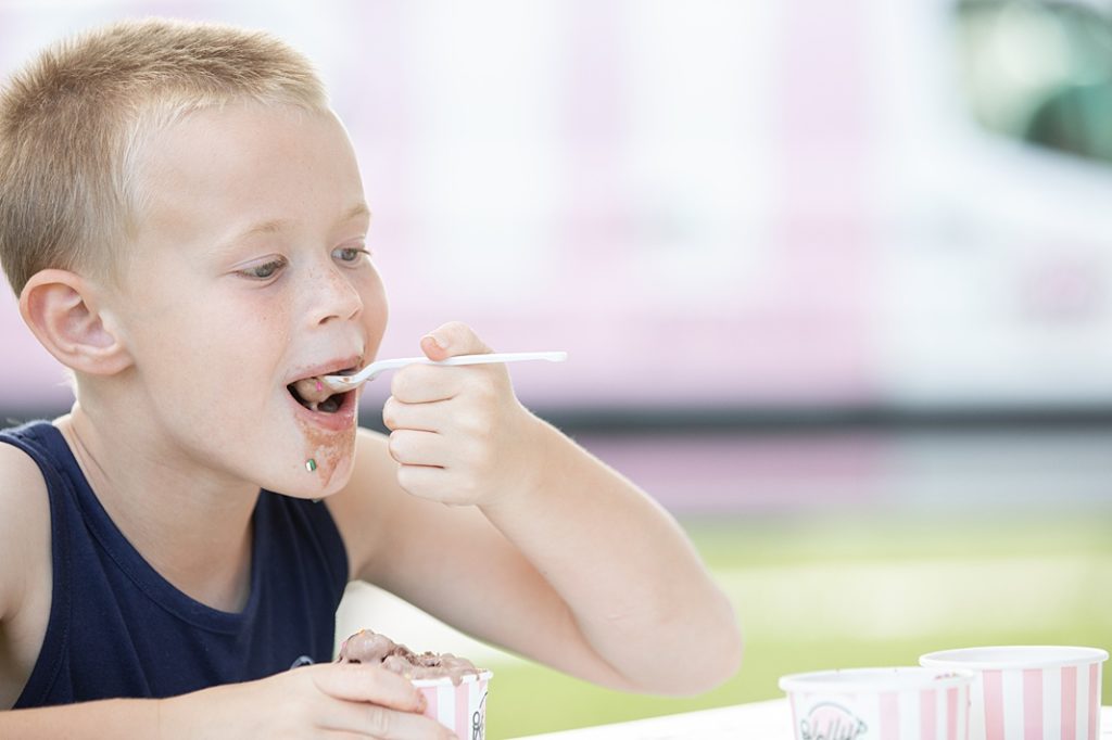 little boy smiling while eating ice cream