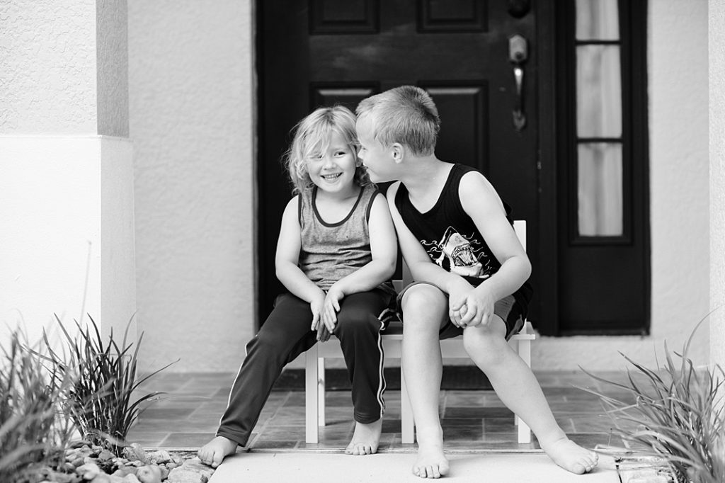 siblings whispering to each other at a summer story session